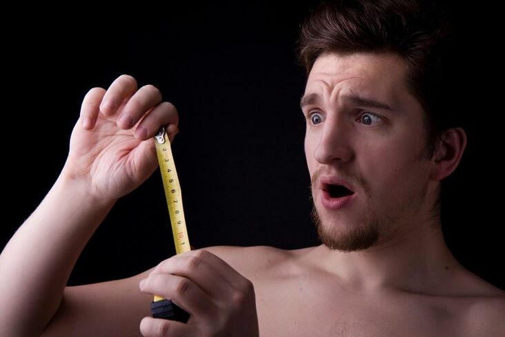 Un uomo con una roulette misura un membro prima dell'operazione per aumentare